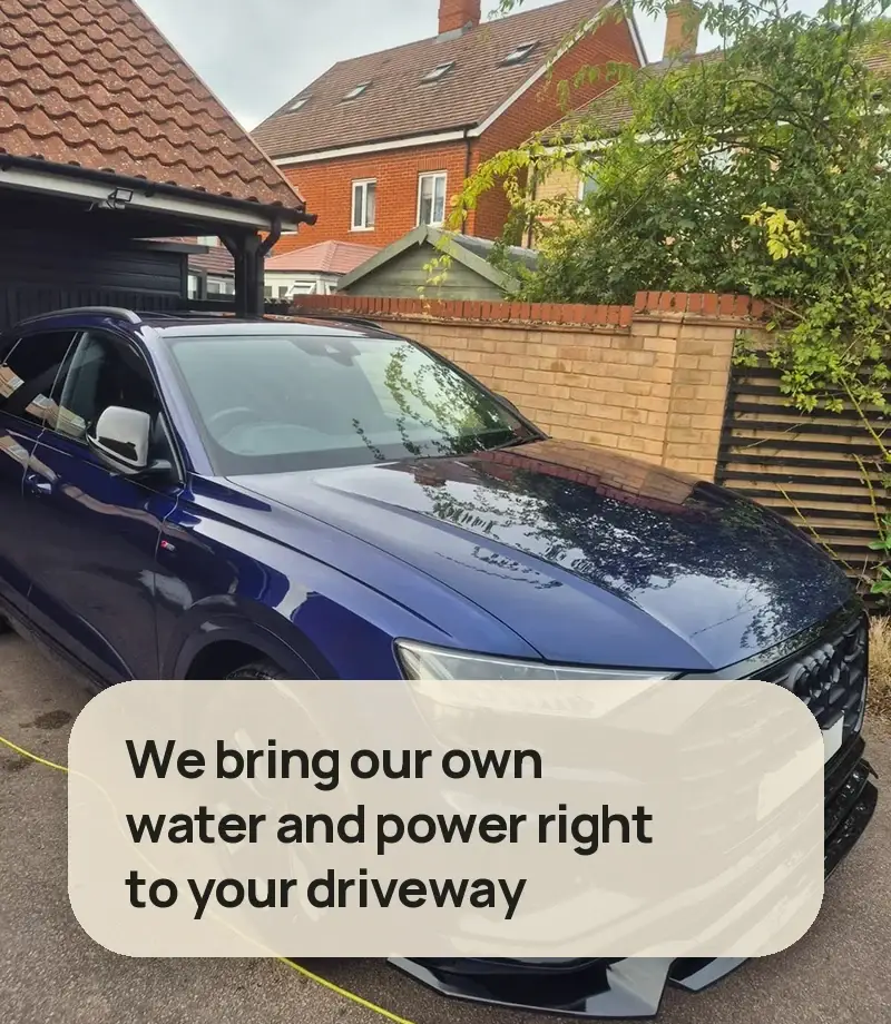 We bring our own water and power right to your driveway - dark blue Audi Q8 on a driveway with our power cable running across the ground