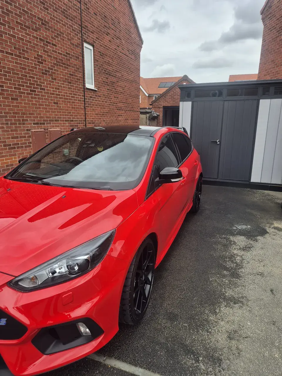 Bright red Ford Focus RS on a driveway with clean paint and wheels