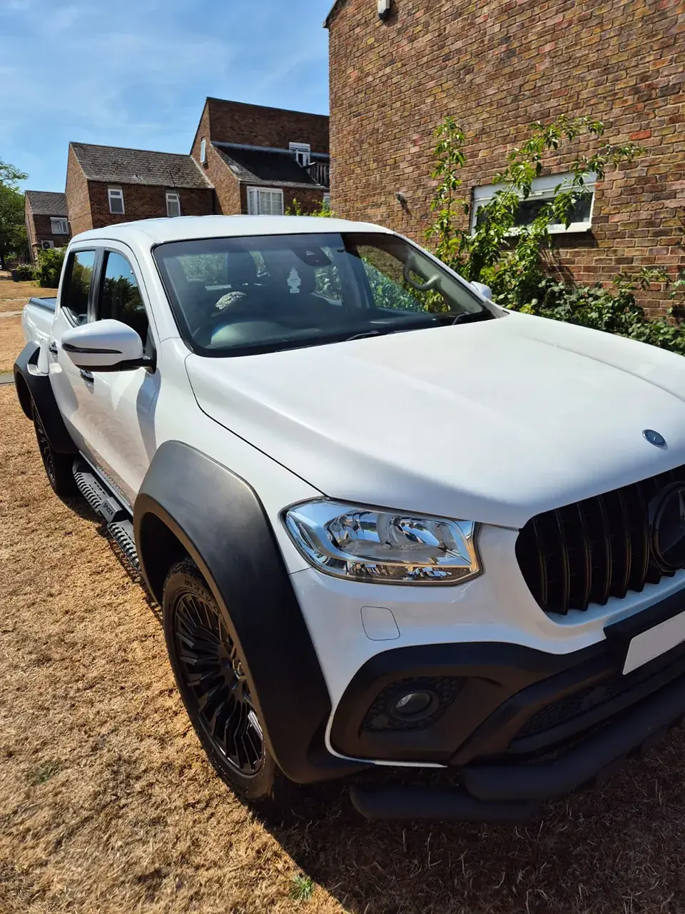 White Mercedes X-Class pickup with black wheel arches after cleaning